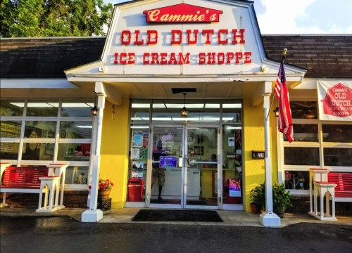 Exterior of Cammie's Old Dutch Ice Cream Shoppe, featuring a bright yellow facade and large windows.