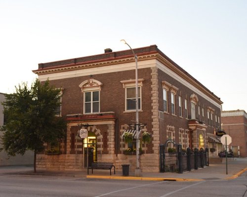 Historic brick building with decorative features, street lamp, and trees, set in a quiet urban environment.