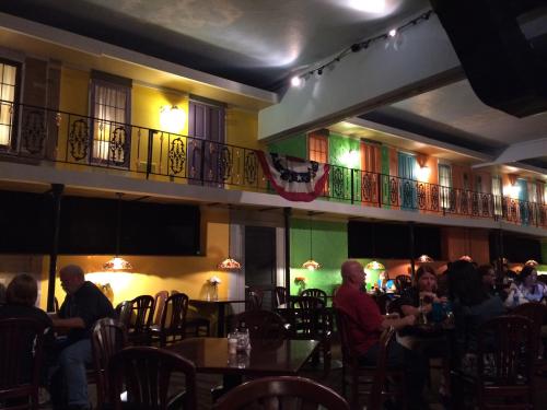 A vibrant restaurant interior with colorful walls, decorative lamps, and patrons dining at wooden tables.