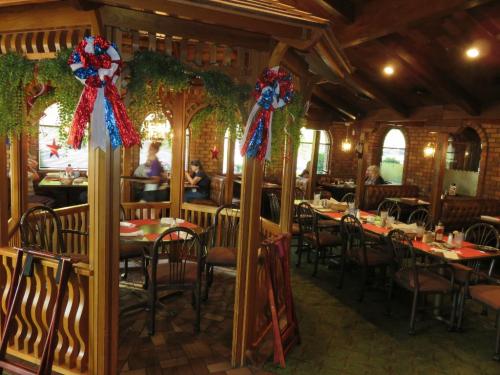 Cozy restaurant interior with wooden decor, festive ribbons, and tables set for dining.