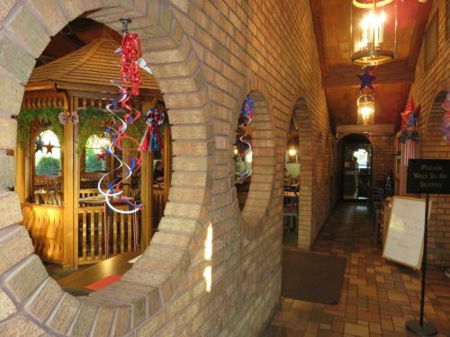 Interior of a restaurant featuring brick walls, circular windows, and festive decorations in red, white, and blue.
