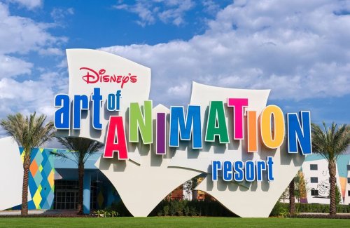 Colorful sign for Disney's Art of Animation Resort, featuring vibrant letters and palm trees under a blue sky.