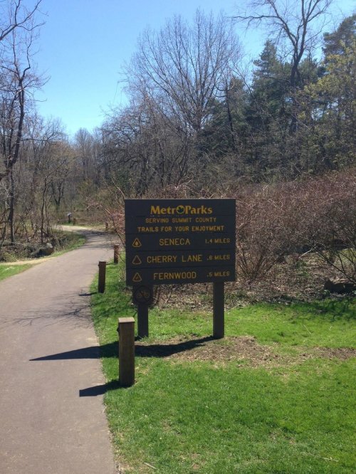 Signpost for MetrO'Parks trails in Summit County, listing distances to Seneca, Cherry Lane, and Fernwood.