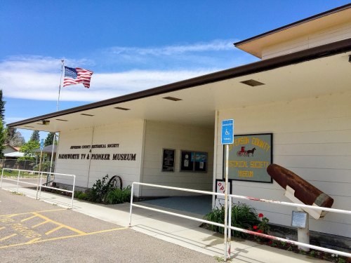 Exterior of the Jefferson County Historical Society Museum, featuring a flag and signage for the museum.