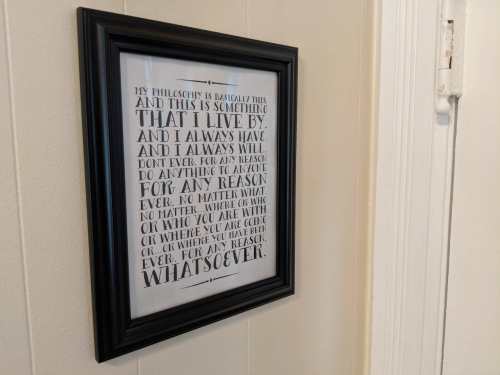 A framed quote on a wall expressing a personal philosophy about living authentically and without conditions.