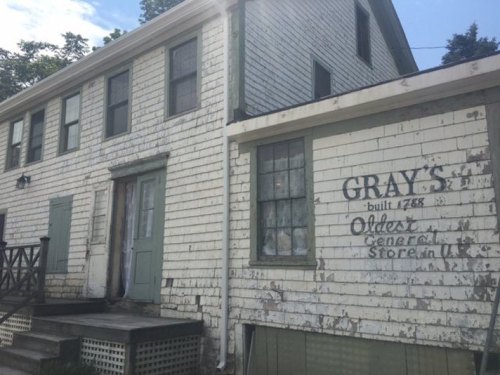 Historic building with peeling white paint, featuring a sign for "Gray's Oldest General Store" established in 1788.