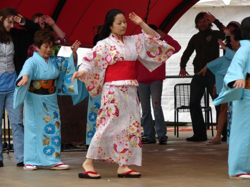 A group of women in colorful kimonos performing a traditional dance on stage.