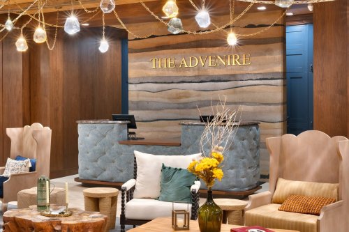 Cozy hotel lobby with a reception desk, stylish seating, and decorative lighting. Warm wood tones and modern decor.