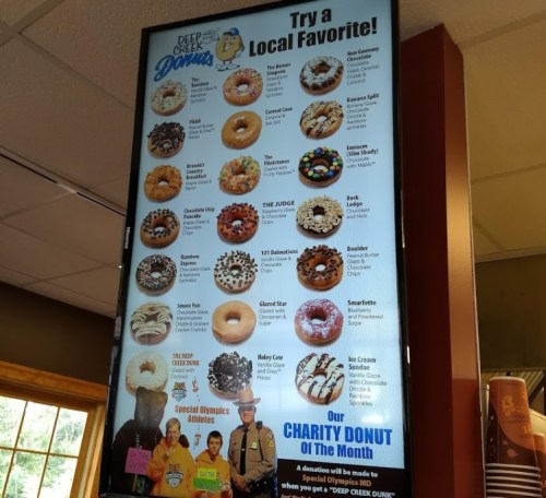 Menu board featuring various donut options, including flavors and special charity donut of the month.