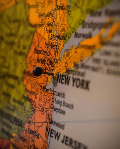 Close-up of a map highlighting New York and New Jersey, with a pin marking a specific location.
