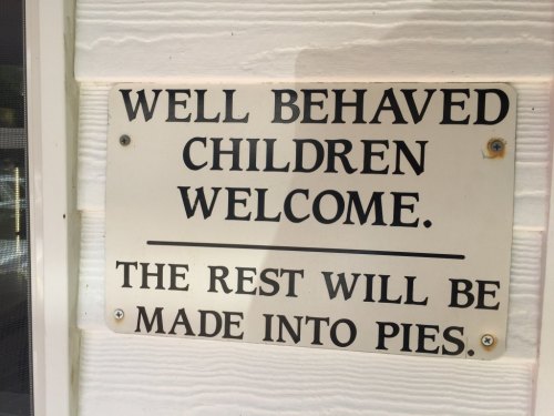 Sign on a wall reading: "Well behaved children welcome. The rest will be made into pies."