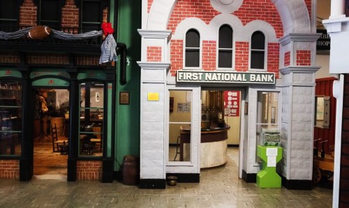 A replica of a bank entrance with a brick archway, labeled "First National Bank," in a vintage-style setting.