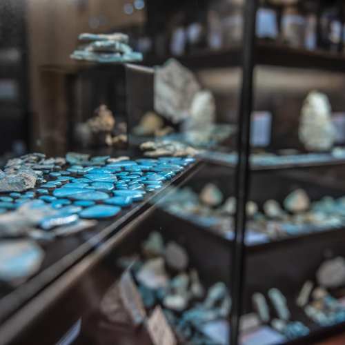 Close-up of a display case filled with various turquoise stones and minerals, showcasing their vibrant colors and textures.