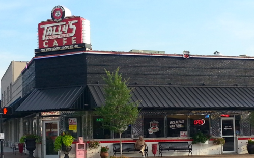 Exterior of Tally's Good Food Cafe, featuring a vintage sign, open storefront, and outdoor seating area.
