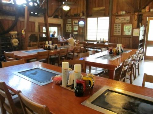 A rustic dining area with wooden tables, condiments on each table, and a cozy atmosphere.