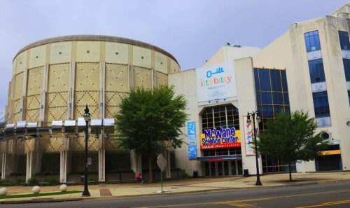Exterior view of the McWane Science Center, featuring a round building and IMAX theater signage, surrounded by trees.