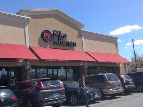 Exterior of Pike Kitchen with red awnings, parked cars, and a clear blue sky in the background.