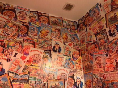A wall covered in colorful, vintage posters featuring cartoon characters and playful slogans.