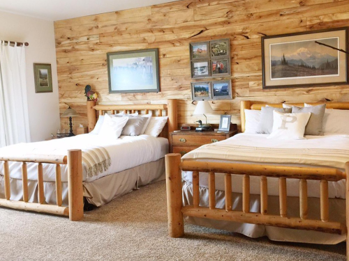 Cozy bedroom with two wooden beds, rustic decor, and a warm, inviting atmosphere.