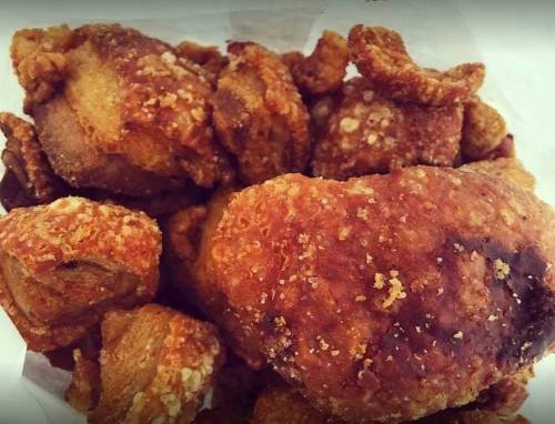 A close-up of crispy, golden-brown fried food pieces, showcasing a crunchy texture and irregular shapes.
