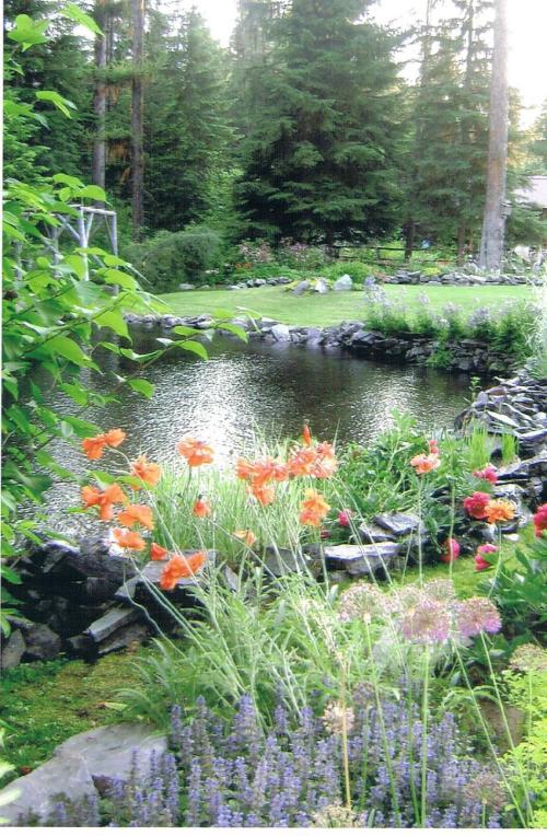A serene garden scene featuring colorful flowers around a tranquil pond, surrounded by tall trees and lush greenery.