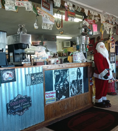 A cozy diner counter decorated with vintage posters, a Santa figure, and a coffee machine, creating a festive atmosphere.
