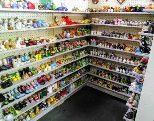 A colorful display of various decorative figurines and collectibles arranged on shelves in a store.