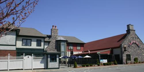 A charming restaurant with a stone facade and outdoor seating, set against a clear blue sky.