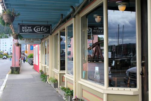 A quaint café with large windows, reflecting a waterfront view and colorful buildings in a small town.