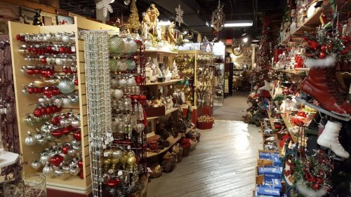A festive store aisle filled with colorful Christmas decorations, ornaments, and holiday-themed items on display.