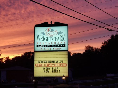 Sign for Wright's Farm Restaurant and Gift Shop at sunset, announcing new offerings in the gift shop.