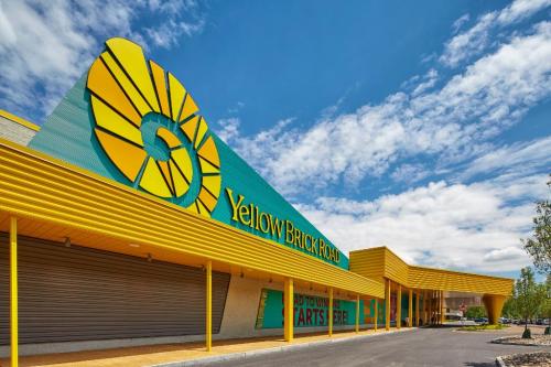 Exterior of a building with a bright yellow and green design, featuring the words "Yellow Brick Road" on the facade.