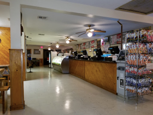 Interior of a casual dining restaurant featuring a counter, menu boards, and snack displays.