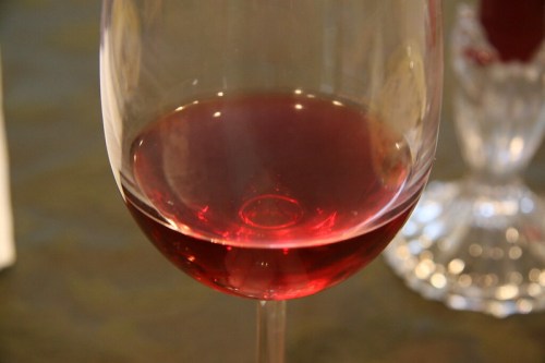 A close-up of a glass filled with red wine, showcasing its rich color and clarity.