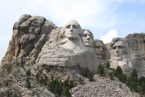 Mount Rushmore featuring the carved faces of four U.S. presidents: Washington, Jefferson, Roosevelt, and Lincoln.