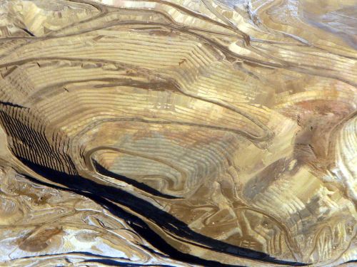 Abstract patterns of swirling gold and black textures, resembling natural formations or artistic brush strokes.