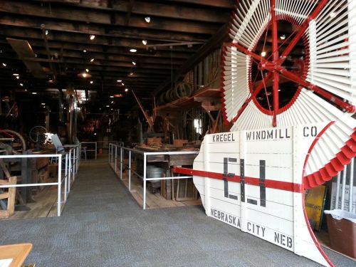 Interior of a museum showcasing vintage windmill equipment, featuring a large windmill display and various artifacts.
