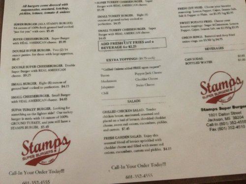 Menu for Stamps Super Burgers featuring burgers, salads, toppings, and beverages with prices listed.