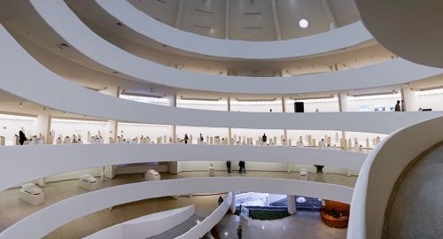 Interior view of the Guggenheim Museum, showcasing its spiral architecture and visitors exploring the exhibits.