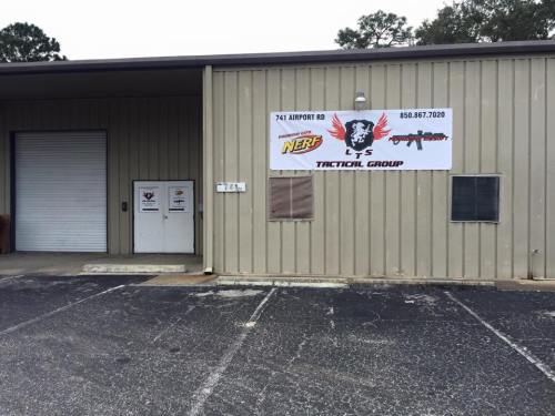 Exterior of a building with a sign for "LS Tactical Group" and a banner promoting Nerf activities.