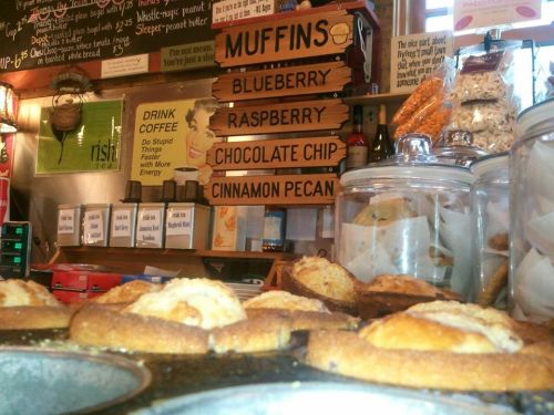 A display of freshly baked muffins with flavors like blueberry, raspberry, chocolate chip, and cinnamon pecan.