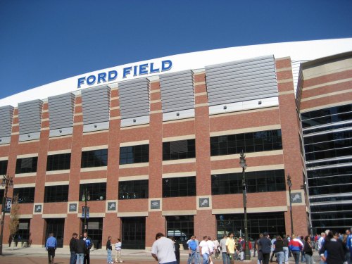Exterior view of Ford Field with crowds of people entering on a clear day.