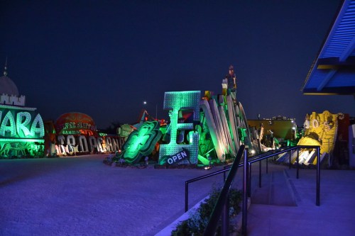 Colorful neon signs and sculptures illuminated at night in a vibrant outdoor art installation.