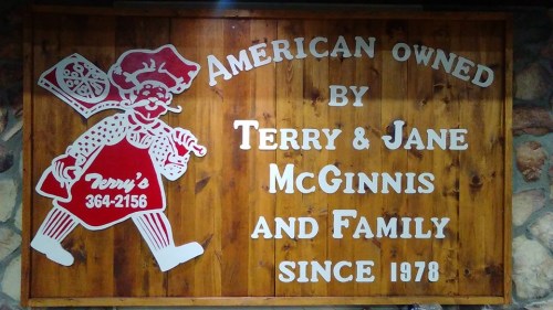 Sign featuring a cartoon chef, stating "American Owned by Terry & Jane McGinnis and Family since 1978."