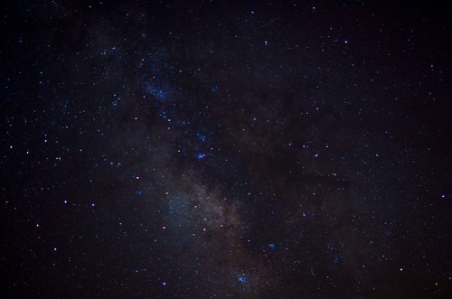 A starry night sky filled with countless stars and a faint glimpse of the Milky Way galaxy.