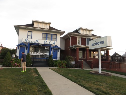 Two historic houses in Detroit, one labeled "Hitsville U.S.A." and the other "Motown Museum," with a visitor nearby.