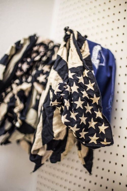 A wrinkled American flag hanging on a pegboard, showcasing its stars and stripes design.