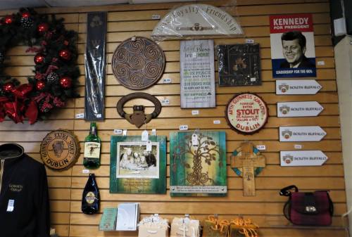 A display of various decorative items, including signs, artwork, and bottles, on a wooden wall.