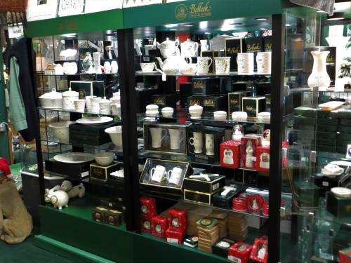 Display case filled with various porcelain items, including dishes, cups, and decorative pieces.