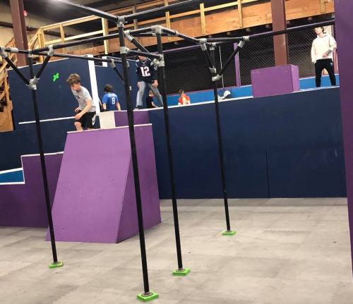 A gym with colorful climbing structures and kids navigating obstacles in a playful environment.